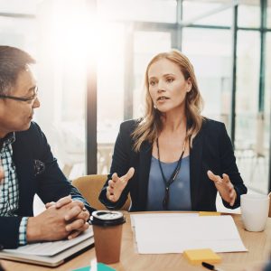 Office, meeting and business people with documents in discussion for negotiation, proposal and planning. Employee, communication and idea in consultation for b2b merger, acquisition and consolidation.